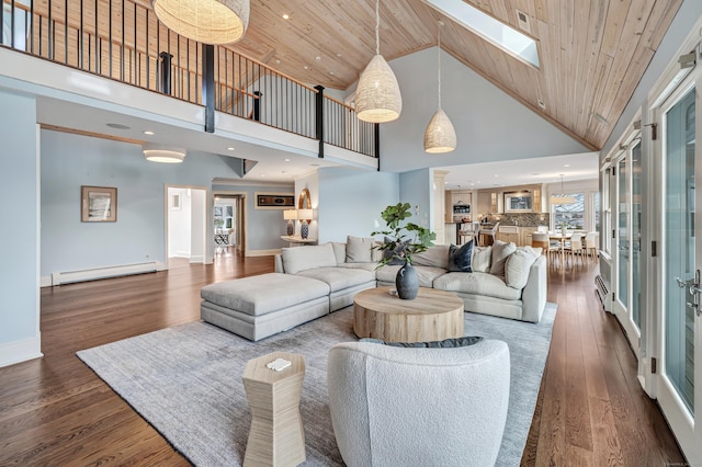living room with wood finished floors, high vaulted ceiling, wood ceiling, a baseboard heating unit, and a skylight