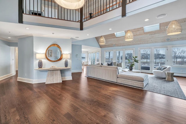 living room with baseboards, recessed lighting, a high ceiling, and wood finished floors