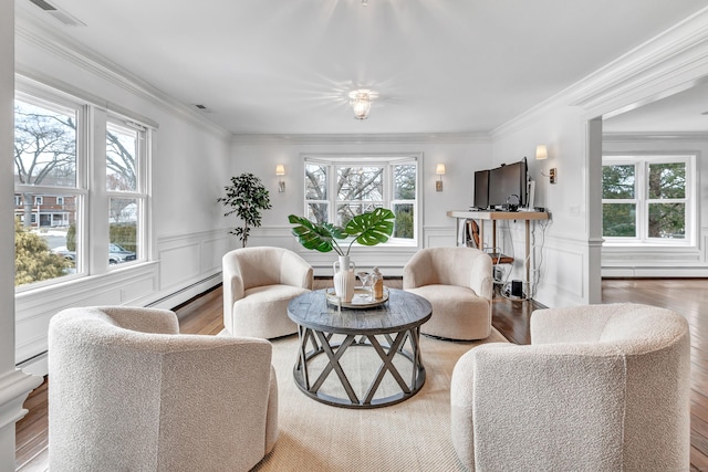 living room featuring visible vents, a wainscoted wall, wood finished floors, a baseboard radiator, and a baseboard heating unit