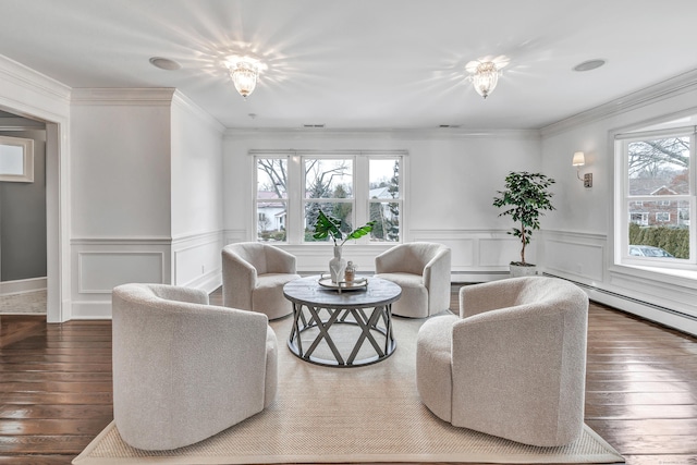 living room with plenty of natural light, wainscoting, hardwood / wood-style flooring, and a baseboard heating unit