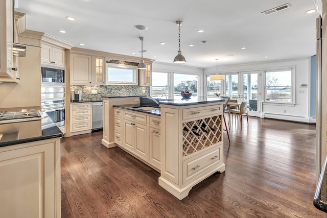 kitchen featuring a baseboard heating unit, cream cabinetry, and dark countertops