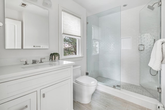 bathroom with visible vents, tile patterned flooring, a stall shower, vanity, and toilet