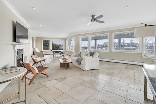 living room featuring crown molding, ceiling fan, baseboard heating, a glass covered fireplace, and recessed lighting