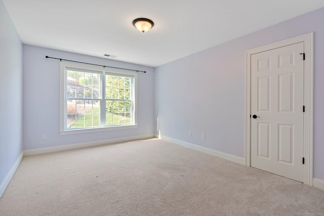 unfurnished room featuring carpet floors, baseboards, and visible vents