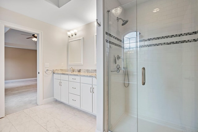 full bathroom featuring vanity, marble finish floor, baseboards, ceiling fan, and a shower stall