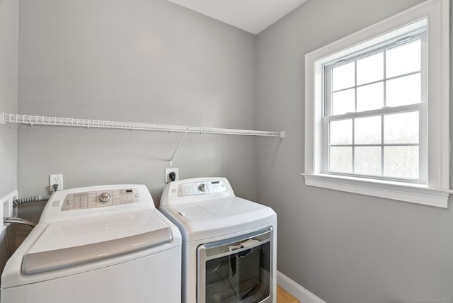 washroom with laundry area, baseboards, and washing machine and dryer