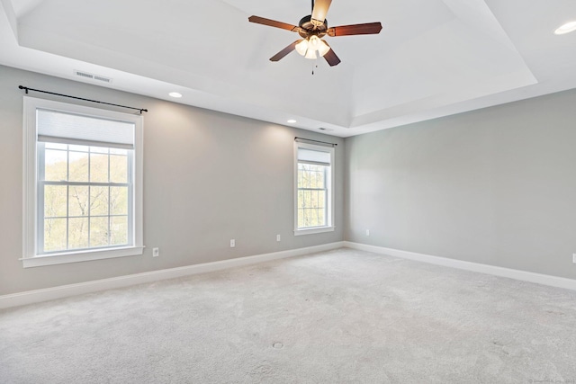 carpeted spare room with visible vents, recessed lighting, and a tray ceiling