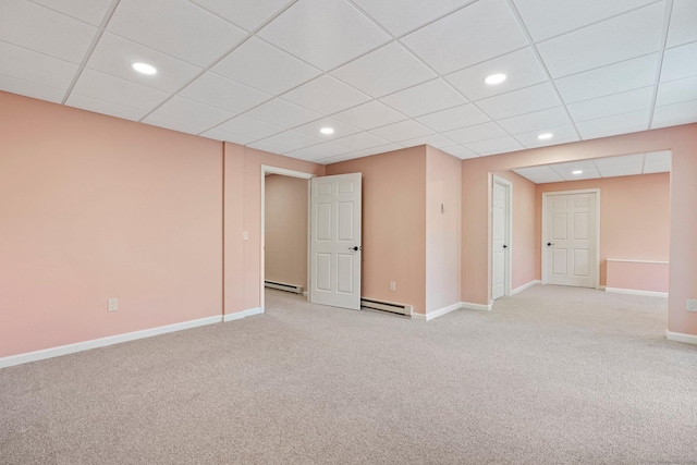 spare room with baseboards, a baseboard heating unit, baseboard heating, and light carpet