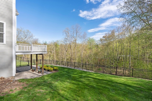 view of yard featuring a forest view, a patio, and a fenced backyard