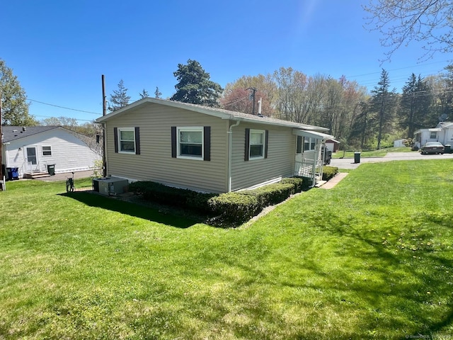 view of side of property featuring a lawn and central air condition unit