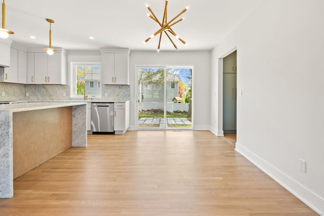 kitchen with decorative light fixtures, tasteful backsplash, stainless steel dishwasher, a chandelier, and light wood-style flooring