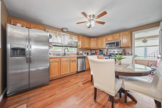 839 Washington Avenue Extension, Waterbury, CT 06708 - kitchen with stainless steel appliances, ceiling fan, light wood finished floors, a sink, and a kitchen breakfast bar