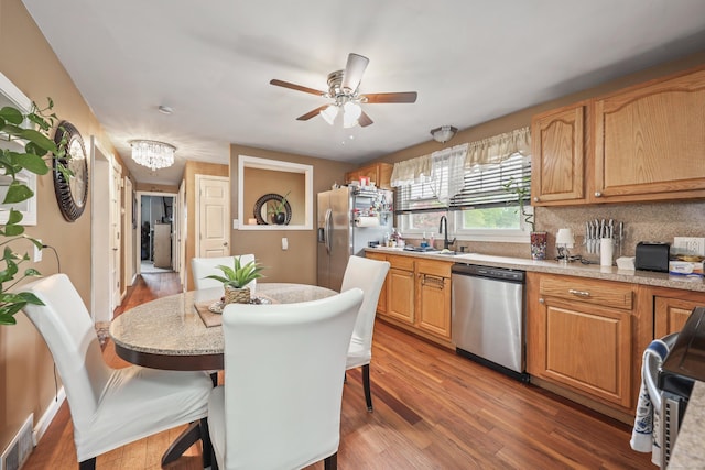 839 Washington Avenue Extension, Waterbury, CT 06708 - kitchen with stainless steel dishwasher, fridge with ice dispenser, a breakfast bar area, and light countertops