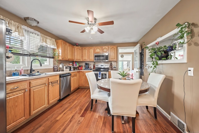 839 Washington Avenue Extension, Waterbury, CT 06708 - kitchen featuring appliances with stainless steel finishes, a sink, wood finished floors, light countertops, and a ceiling fan
