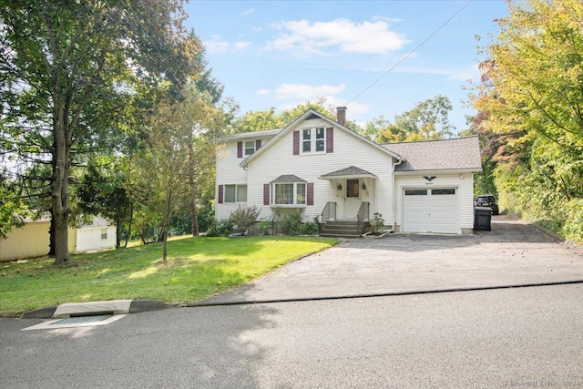 colonial inspired home with an attached garage, a front lawn, driveway, and a chimney