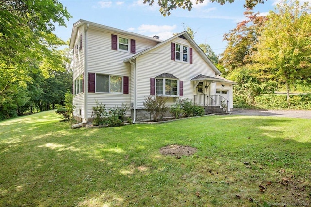 traditional-style house featuring a garage, driveway, and a front yard