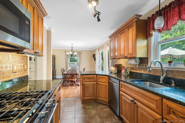 kitchen with backsplash, crown molding, brown cabinets, a sink, and stainless steel appliances
