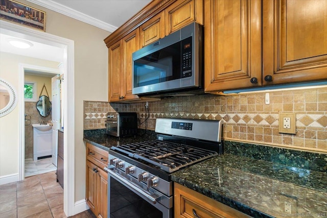 kitchen with ornamental molding, stainless steel appliances, brown cabinets, and tasteful backsplash