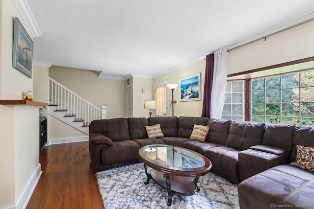 living area with baseboards, ornamental molding, stairs, and wood finished floors