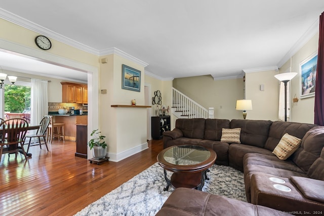 living area with stairway, baseboards, crown molding, and wood finished floors