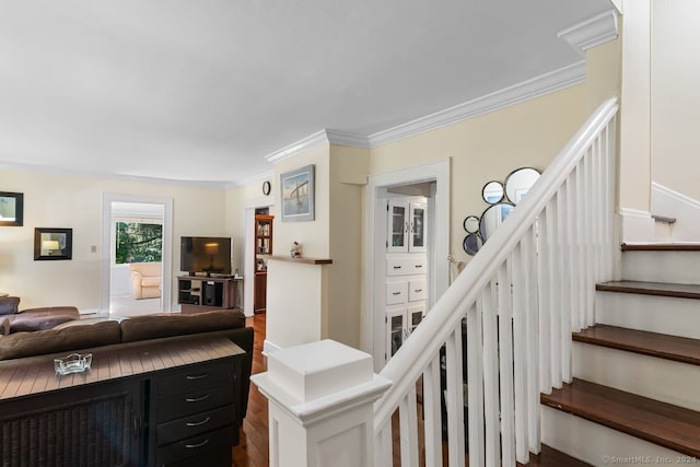 living area featuring crown molding, dark wood-style flooring, and stairway