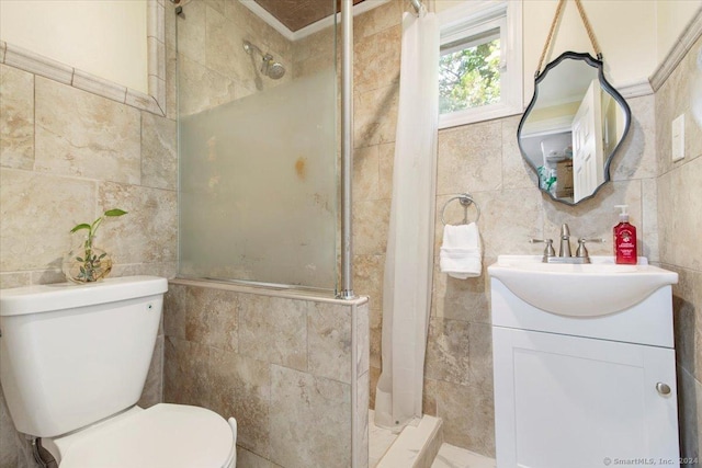 full bathroom with vanity, a stall shower, toilet, and tile walls