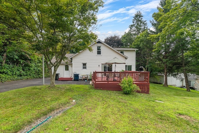 back of house with a wooden deck and a yard