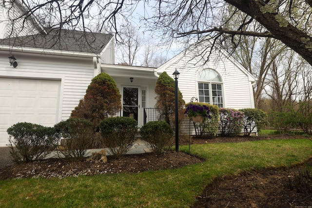 view of front of home featuring an attached garage and a front lawn
