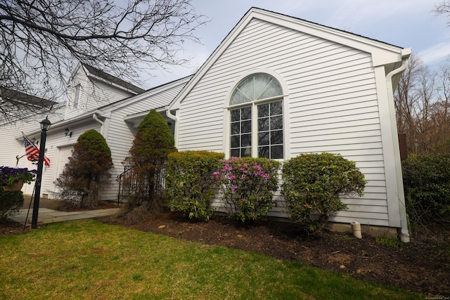 view of property exterior with a yard and a garage