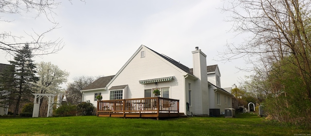back of house with a wooden deck, a yard, a chimney, and cooling unit