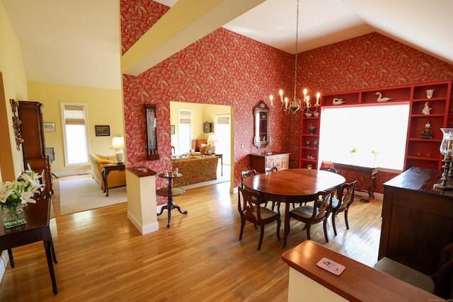 dining area featuring vaulted ceiling, wallpapered walls, wood finished floors, and a chandelier