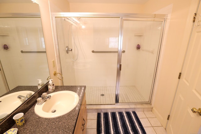 full bath with tile patterned flooring, a stall shower, and vanity
