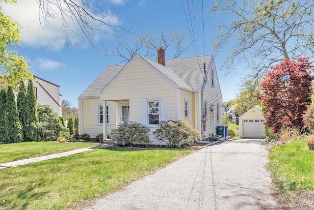 view of front of property with a chimney, an outbuilding, a garage, a front lawn, and a shingled roof