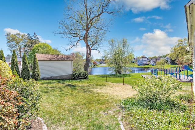 view of yard featuring an outdoor structure, a water view, and fence