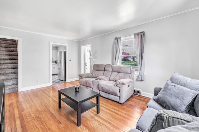 living area featuring crown molding, light wood-style floors, stairs, baseboards, and visible vents