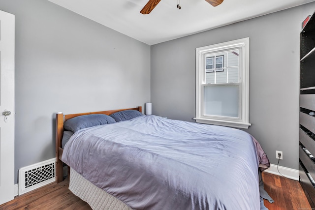 bedroom with ceiling fan, baseboards, visible vents, and wood finished floors
