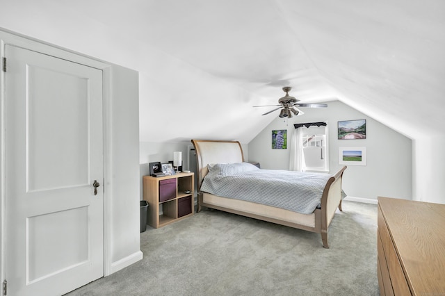 bedroom featuring a ceiling fan, baseboards, light carpet, and vaulted ceiling