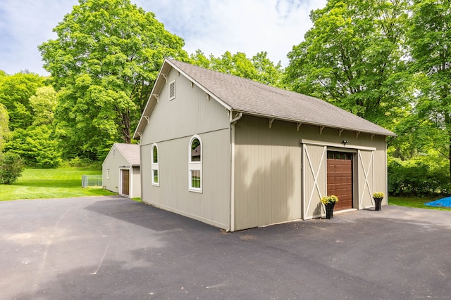 290 Waterville Rd, Avon, CT 06001 - view of property exterior with a detached garage, an outdoor structure, roof with shingles, and a lawn