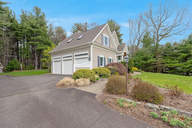view of home's exterior with a lawn, a shingled roof, and aphalt driveway