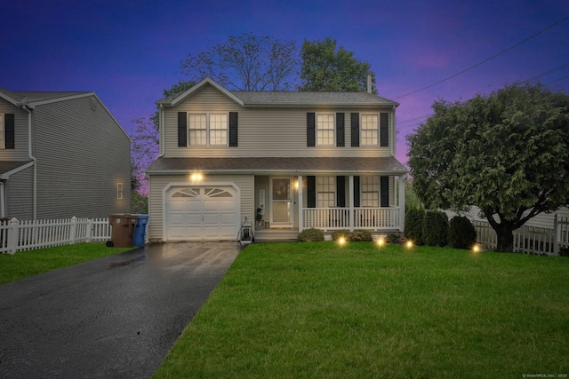 traditional-style house featuring covered porch, an attached garage, asphalt driveway, and roof with shingles