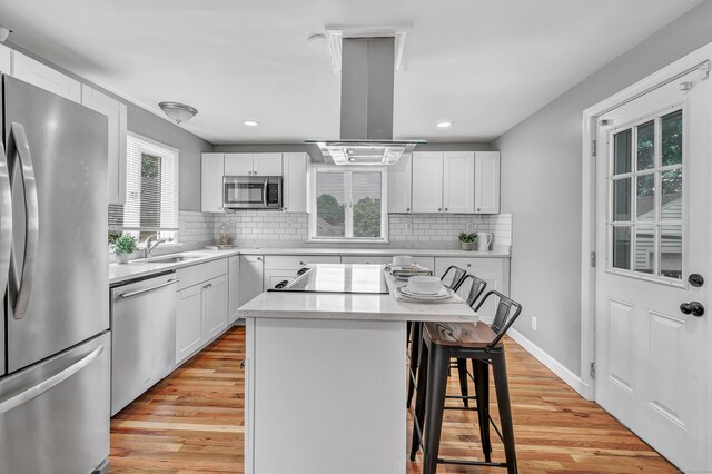 84 Oxford St, Bridgeport, CT 06606 - kitchen with stainless steel appliances, a kitchen breakfast bar, island range hood, light wood-style flooring, and recessed lighting