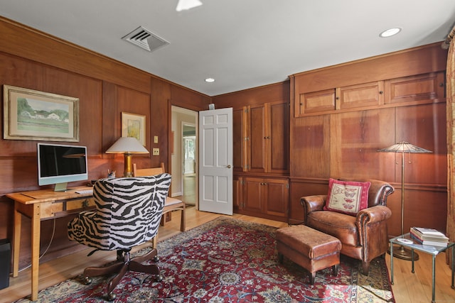 office space featuring visible vents, recessed lighting, light wood-style flooring, and wood walls