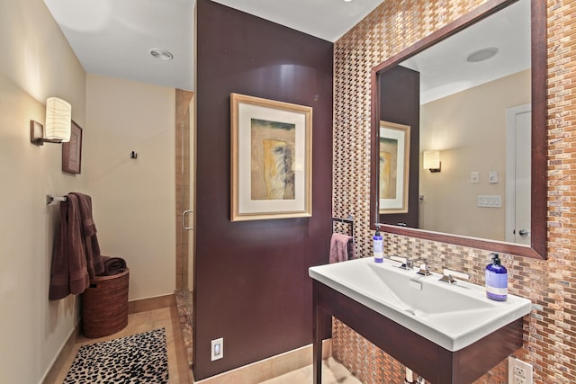 bathroom with baseboards, tile patterned floors, tasteful backsplash, and a shower stall