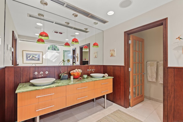bathroom with a sink, a wainscoted wall, and double vanity