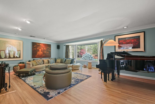 living room with crown molding, baseboards, wood finished floors, and visible vents
