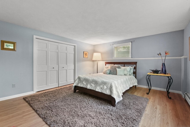 bedroom with baseboards, wood finished floors, and a closet