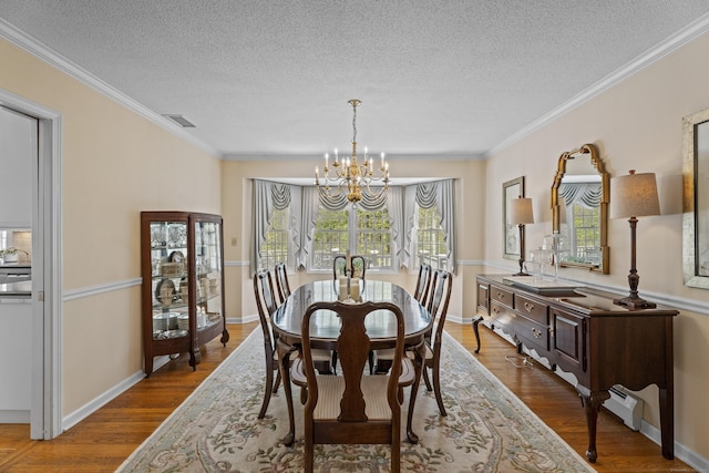 dining space featuring a textured ceiling, a wealth of natural light, visible vents, and a chandelier