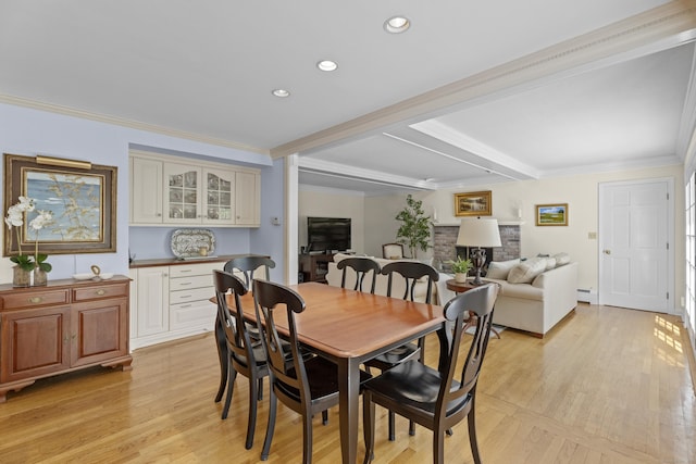 dining space featuring baseboard heating, beam ceiling, light wood-style floors, ornamental molding, and recessed lighting