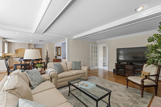 living area with recessed lighting, ornamental molding, wood finished floors, and a baseboard radiator