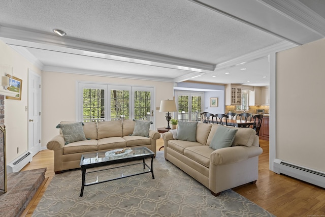 living area featuring a baseboard radiator, a textured ceiling, and wood finished floors
